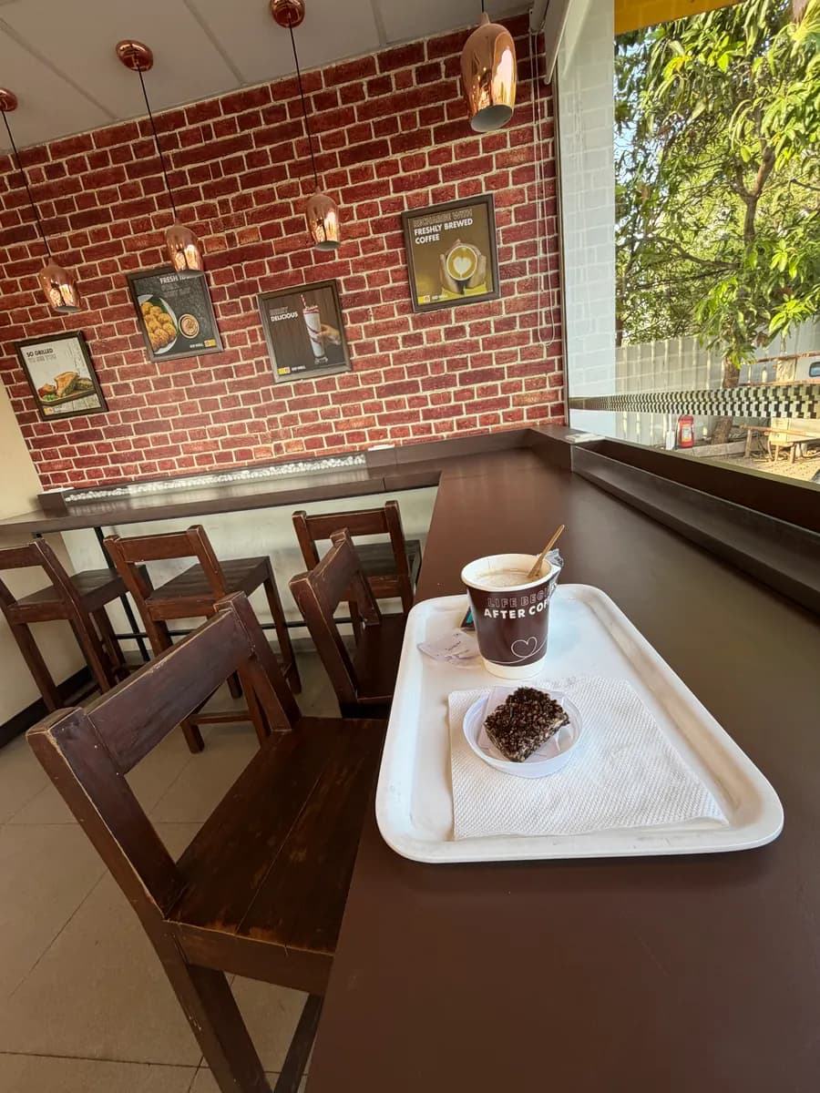 Coffee and a slice of cake on a tray at a roadside café stop